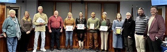 2025 CAC Chairperson Sue Kelly with members of the Board of Commissioners standing with local business owners to present their Community Appearance Awards