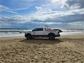 Image of a KDH Ocean Rescue Truck parked on the beach with the ocean in the background