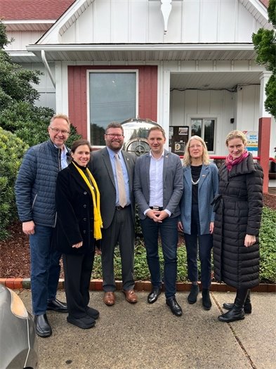 Mayor John Windley recently welcomed members of a delegation from Mecklenburg-Vorpommern Germany to Kill Devil Hills.  The Mayor of Anklam, in Germany, was in attendance. The City of Anklam has historical aviation connections with Kill Devil Hills. In 1891, Otto Lilienthal, a mechanical engineer born in Anklam, achieved the first reproducibly safe gliding flight (now known as hang gliding). Much like Kill Devil Hills is known as the birthplace of aviation, Anklam is known as the birthplace of the “Glider King.” The Wright Brothers credit Otto Lilienthal and his advancements for their success in achieving the first heavier-than-air powered flight. Mayor Windley and the delegation formed a new international relationship to build upon. (We think Mayor Windley introducing the delegation to shrimp and grits really helped seal the deal.)  Members of the delegation that were in attendance include Patrick Dahlemann, Head of the State Chancellery; Juliane Rinas, Head of Division International Relations; Alexander Zysno, Personal Assistant to the Head of the State Chancellery; Michael Galander, Mayor of Hanseatic City Anklam; Dr. Susanne Bocher, Museum Director Mirow Castle.